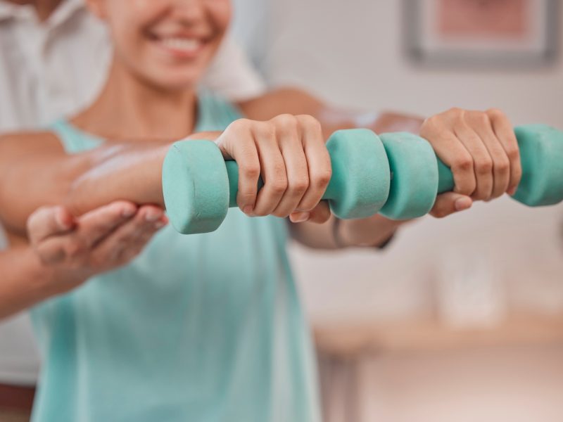 Rehabilitation, physiotherapy and weights of a woman patient in a healthcare clinic consultation. D